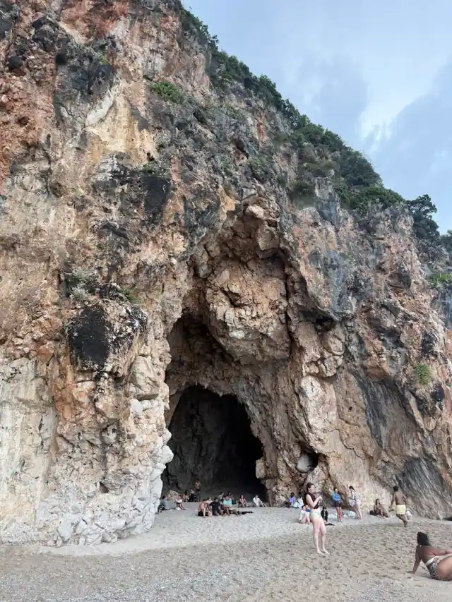 Mouth of Pigeon's Cave in the limestone cliff above the beach