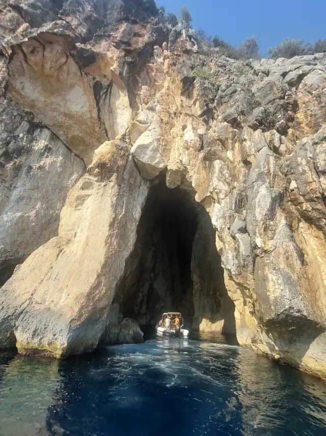 A boat inside the high arch of Pirate's Cave