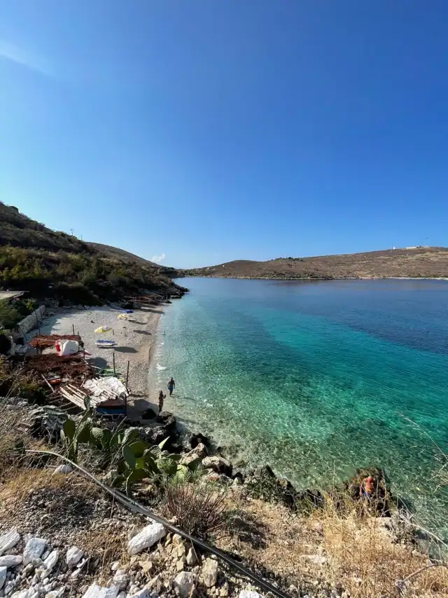 The pebble cove at Porto Palermo with the hills behind