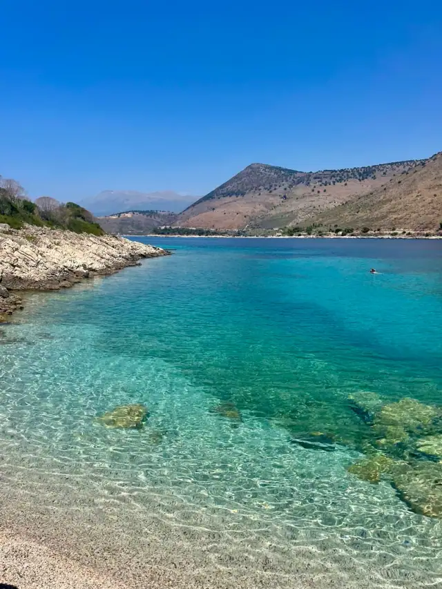 Brilliant turquoise shallows of Porto Palermo bay below the ridge