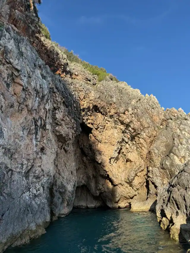 Hidden sea cave inlet with turquoise water beneath karst cliffs near Gjipe on the Albanian Riviera