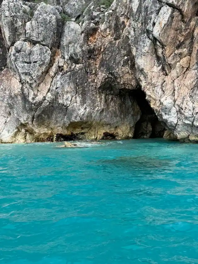 Mouth of Secret Cave with bright turquoise water at its entrance