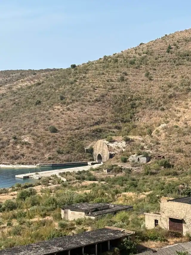Tunnel entrance set into the dry hillside above the water