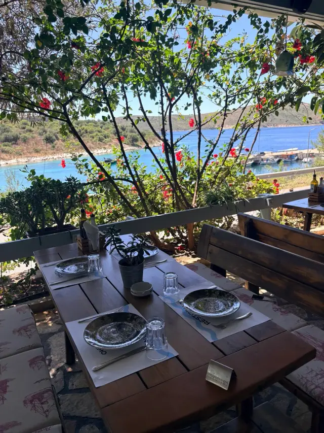 Terrace table set for a seafood meal overlooking Porto Palermo bay at Porto Palermo Restaurant