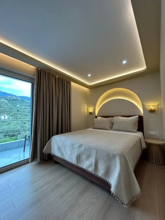 A mountain-view room, a domed arc of light over the bed and the olive-covered hillside through the window