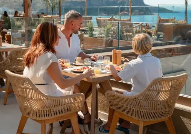 Guests at breakfast on the roof terrace above the bay