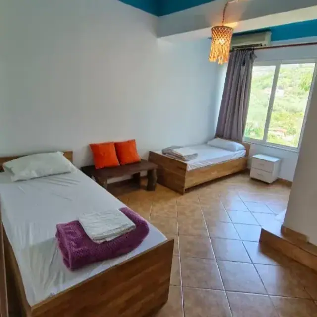 A private twin room with two single beds, tiled floor and a window at Trip'n'Hostel Seaside